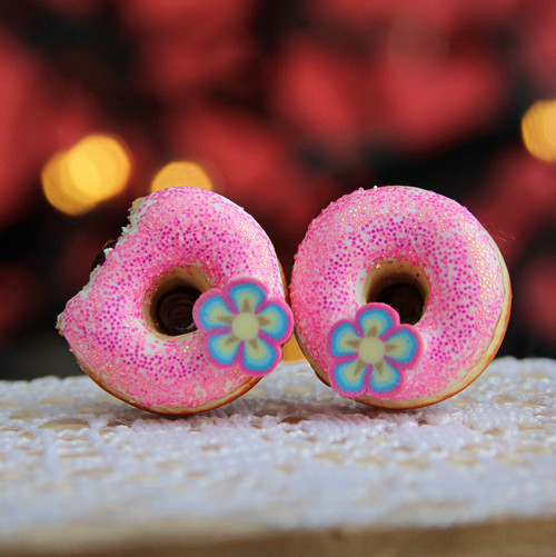 Růžové donuty s kytičkami, jeden nakousnutý
