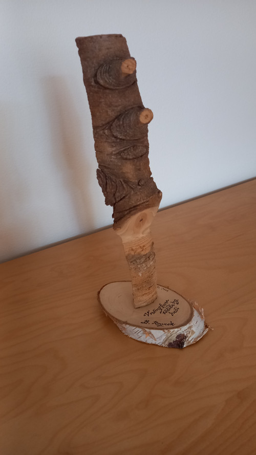 Dřevěný artefakt s citátem z básně B. Reynka