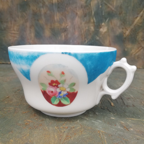 Starožitný porcelánový hrnek s květy.