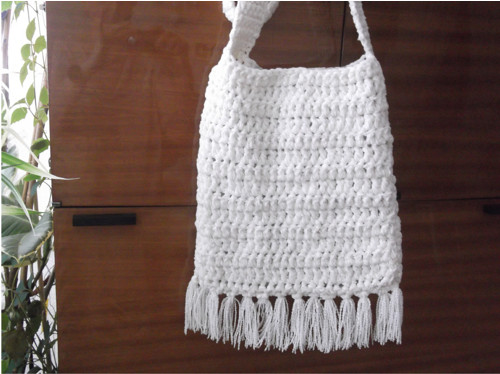 Bílá crossbody kabelka s třásněmi.