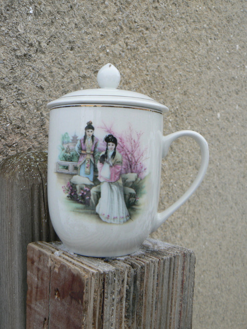 Porcelánový hrnek s pokličkou.