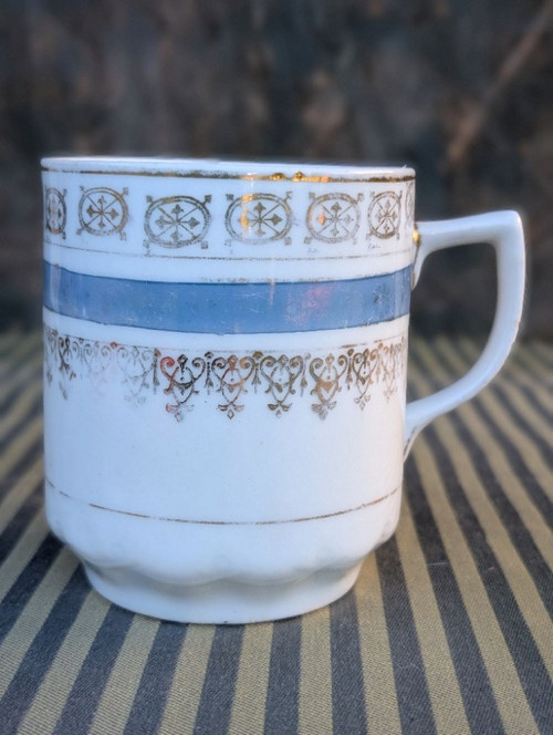 Starožitný porcelánový šálek se zlatým dekorem.