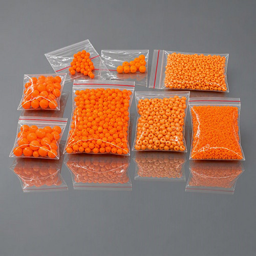 Oranžové neonové korálky různých tvarů a velikostí